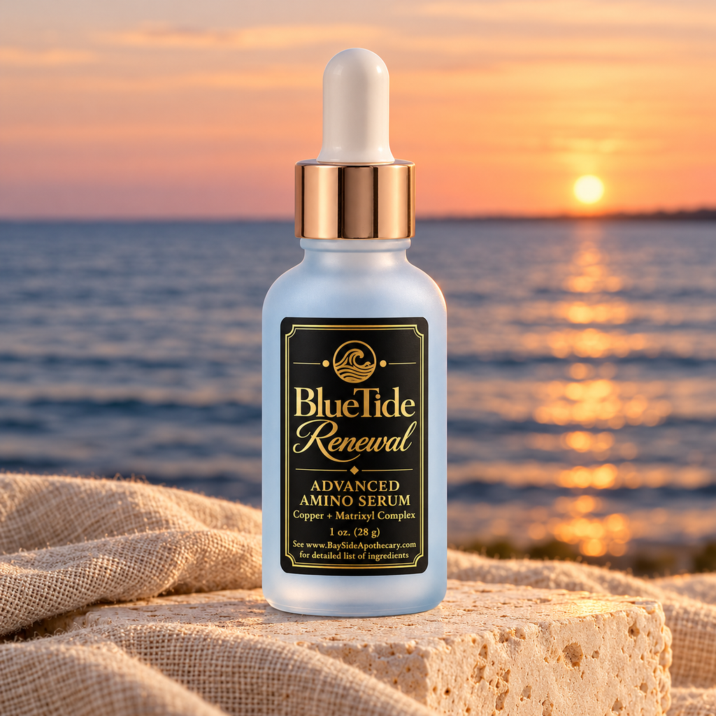 BlueTide Renewal serum bottle on pale stone and linen beside the bay at sunset.