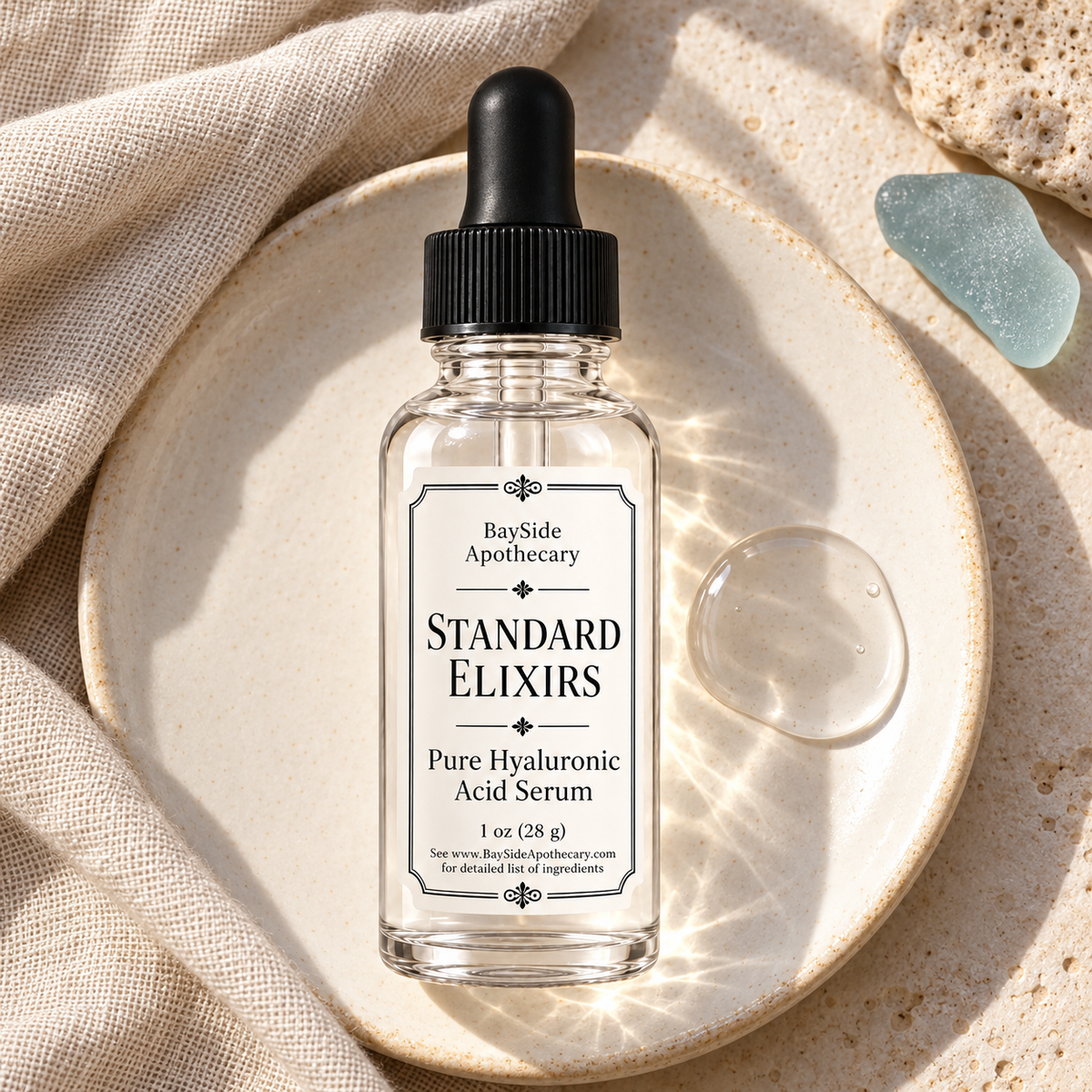 Standard Elixirs serum bottle beside a clear serum swatch on ivory ceramic.